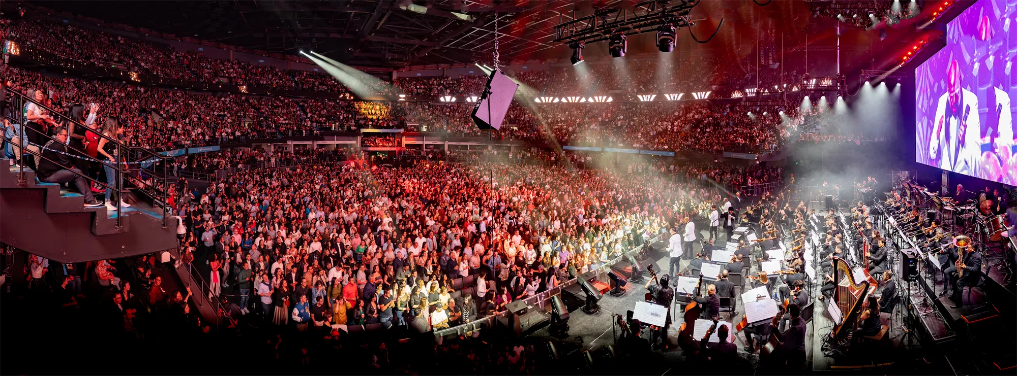 Vista panorámica del recinto lleno, con la orquesta en el escenario.